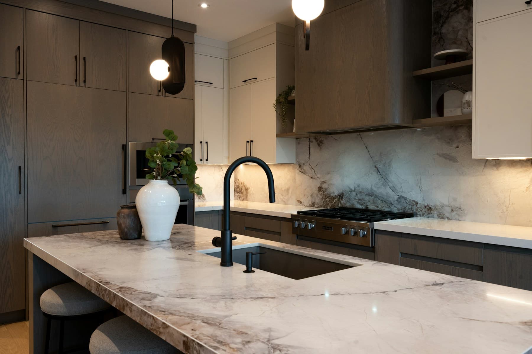Dramatic marble island and full-height stone backsplash